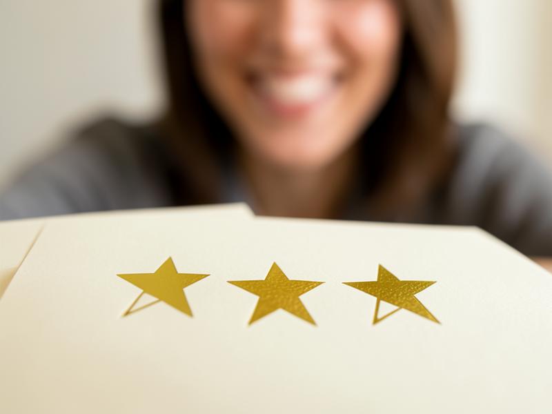 Gold star rating held by a smiling customer